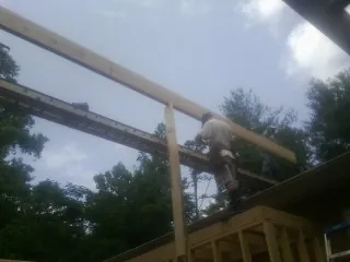 Carpenter setting a ridge beam over a new addition frame — Ice Dam Removal by Roofing Brothers in Blountsville
