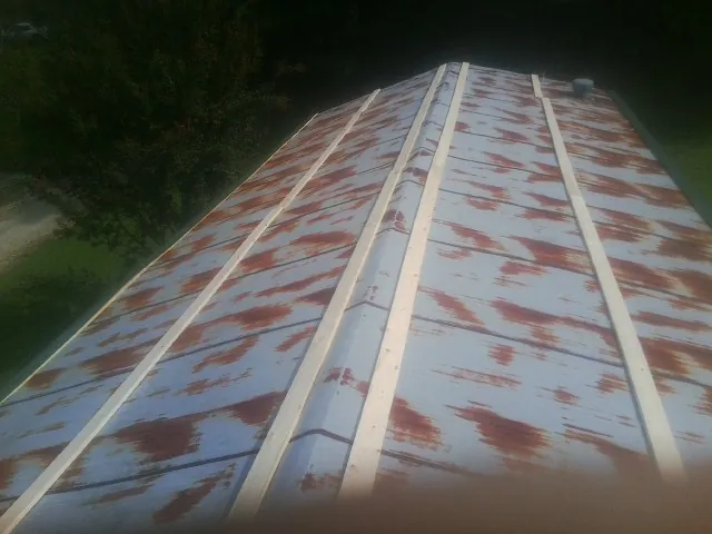 Rusted metal roof panels with new wood purlins before replacement — Storm Damage Roof Repair in Blountsville by Roofing Brothers