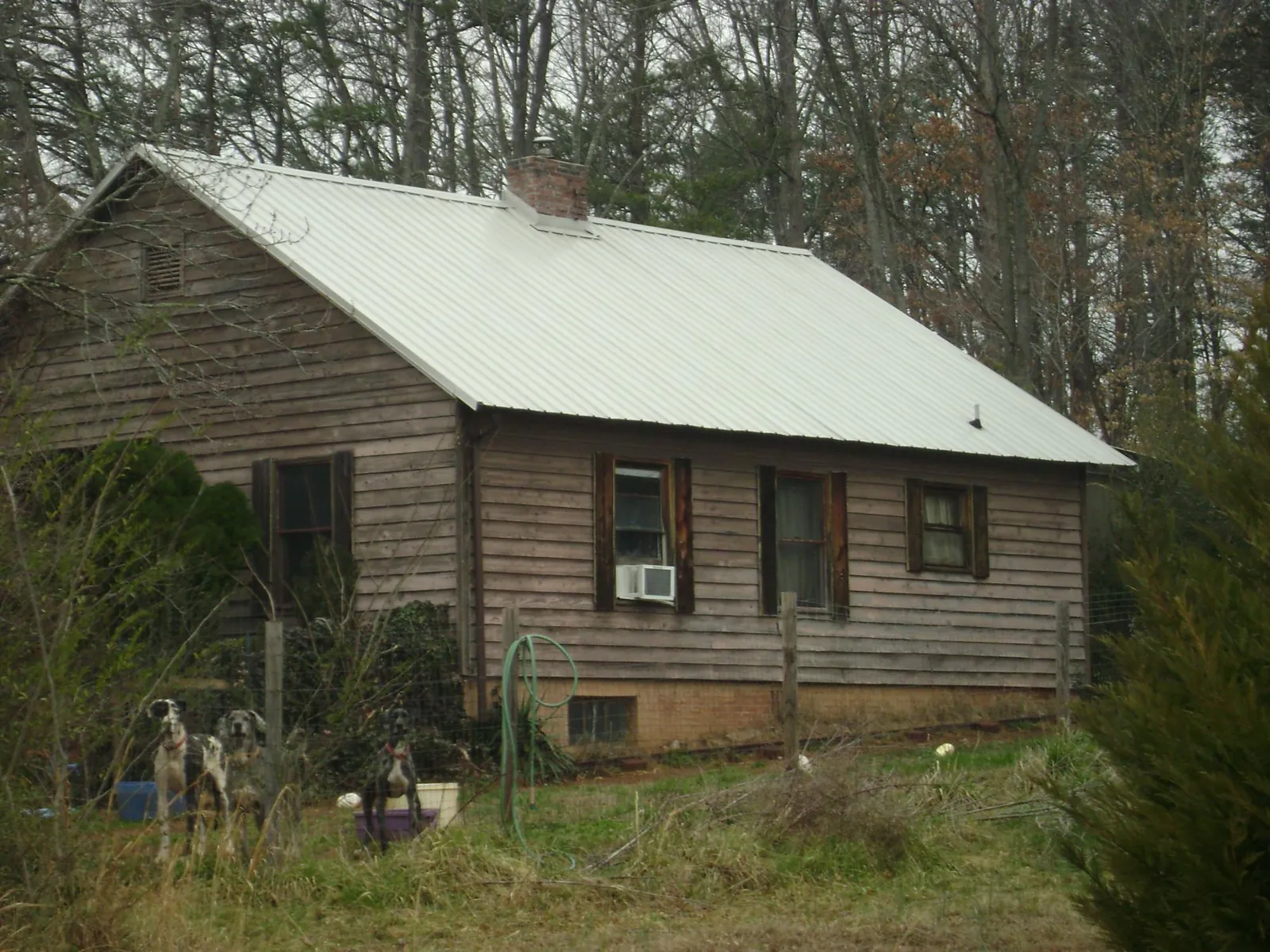 White metal roof on an old wood sided farmhouse, from a Metal Roof Installation job in Blountsville